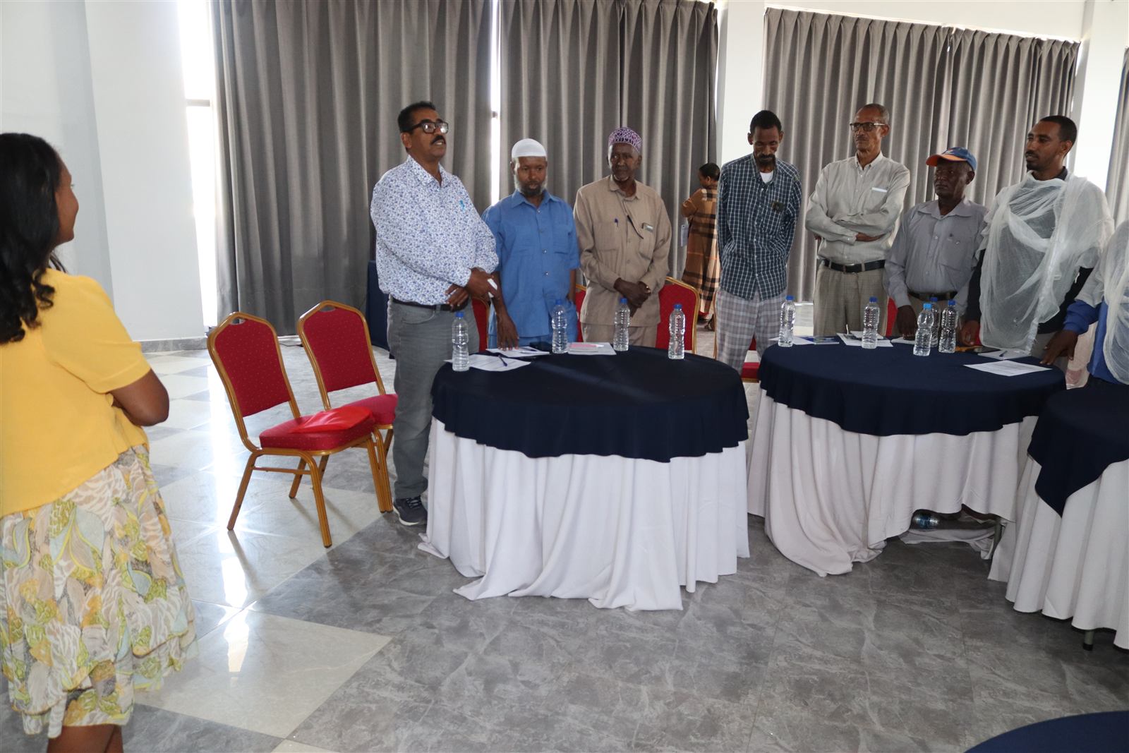 A line of participants, including several community and religious leaders, standing during a session
