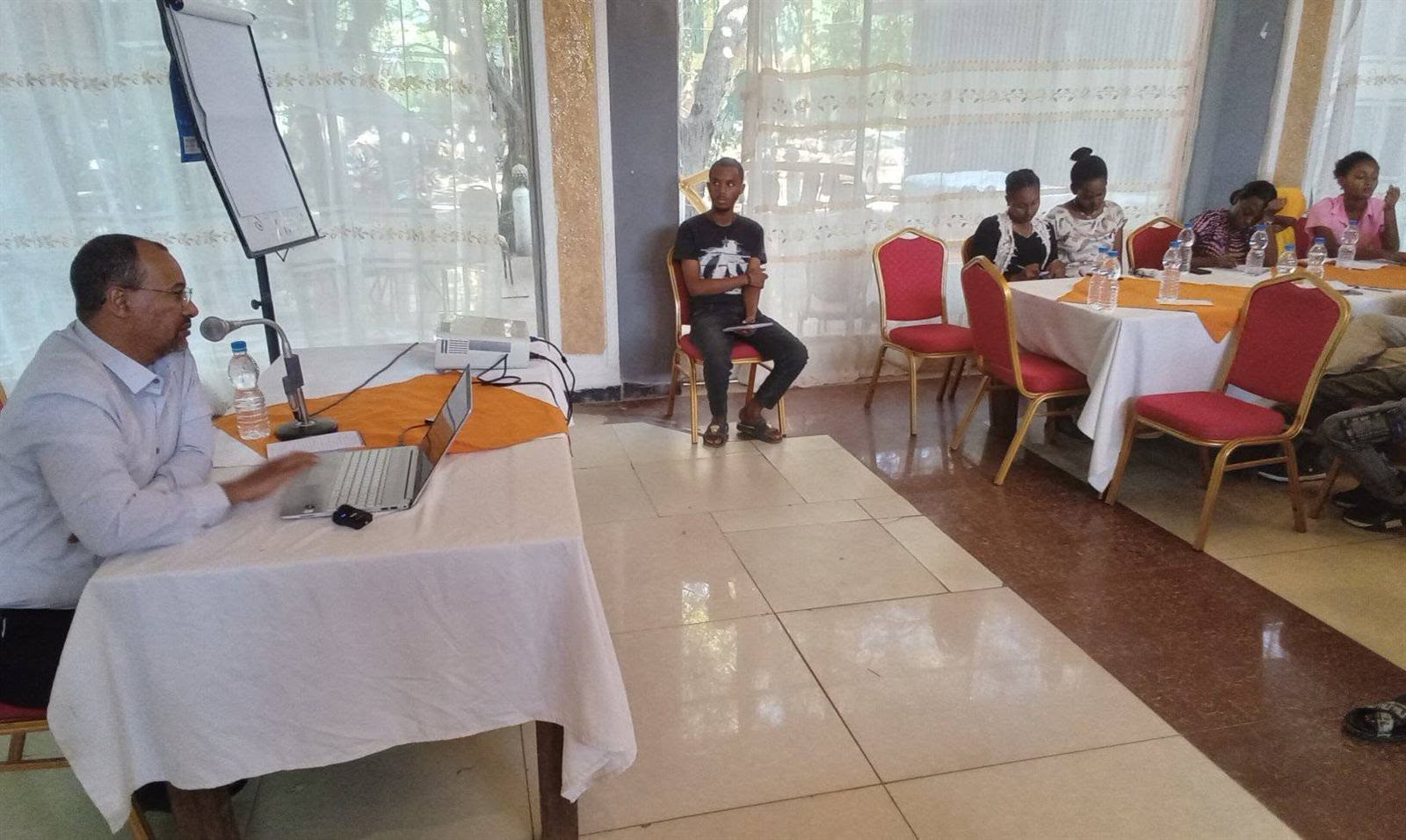 Facilitator presenting via laptop to a mixed young and older audience