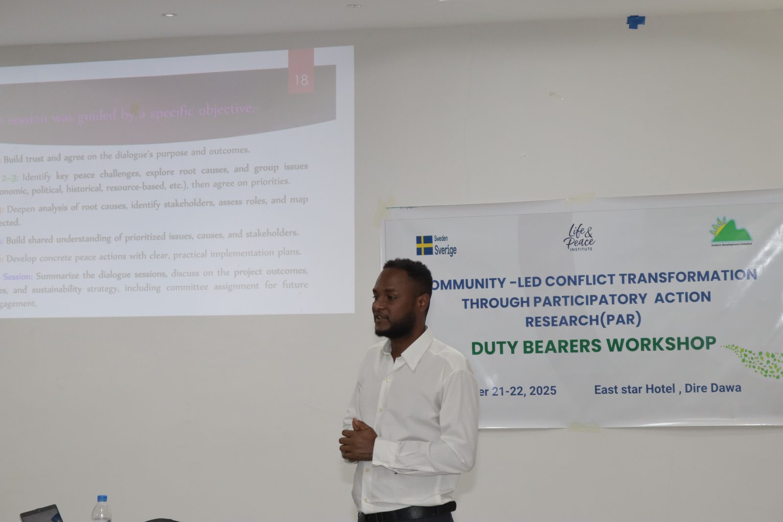 Presenter beside the Duty Bearers Workshop banner, East Star Hotel, Dire Dawa